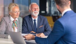 Positive aged couple consulting with insurance agent