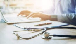 Doctor typing information on Laptop in Hospital office focus on