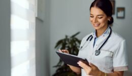 Smiling Medical Professional Using Digital Tablet in Modern Clinic Setting