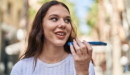Young woman smiling confident talking on the smartphone at street