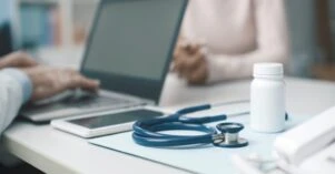 Doctor talking with a patient and typing with his laptop Doctor talking with a patient and typing with his laptop