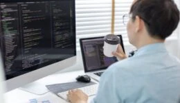 Professional development programmers are sipping coffee in a private office, Working on coding or programming on a computer, Write information or code for the website,  HTML, Javascript, Software.