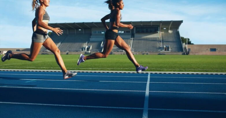 Athletes arrives at finish line on racetrack