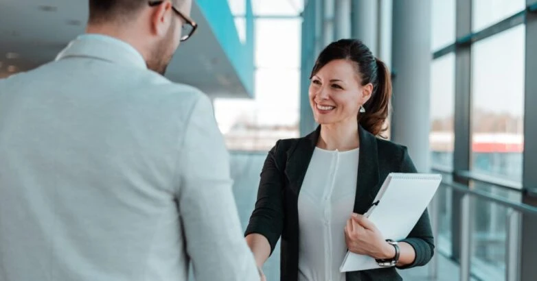Business people handshake near the office building windows.