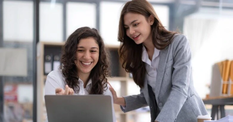 Two young Asian business woman talk, consult, discuss working with new startup project idea presentation analyze plan marketing and investment in the office.